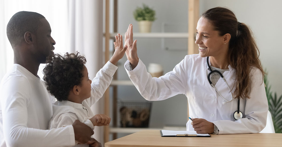 Child with parent giving the doctor a high-five.
